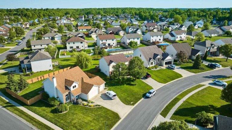 Aerial view of a residential neighborhood in Whitchurch-Stouffville, Ontario, featuring detached homes, tree-lined streets, spacious yards, and well-maintained local roads surrounded by green space.