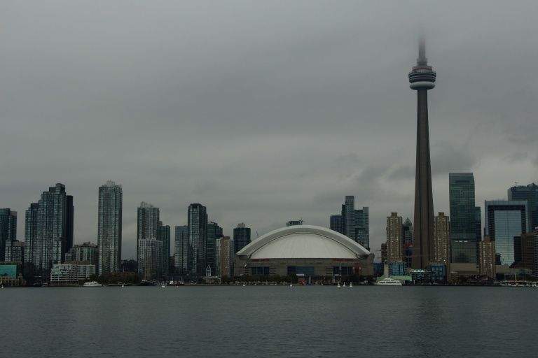 It shows the CN Tower in the background and a road