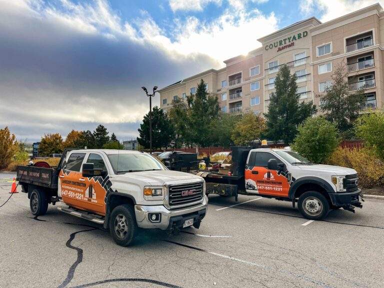 two Action Paving trucks carrying materials for asphalt work