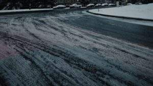 Snow and slush accumulation on a residential asphalt street intersection illustrating winter freeze season conditions.