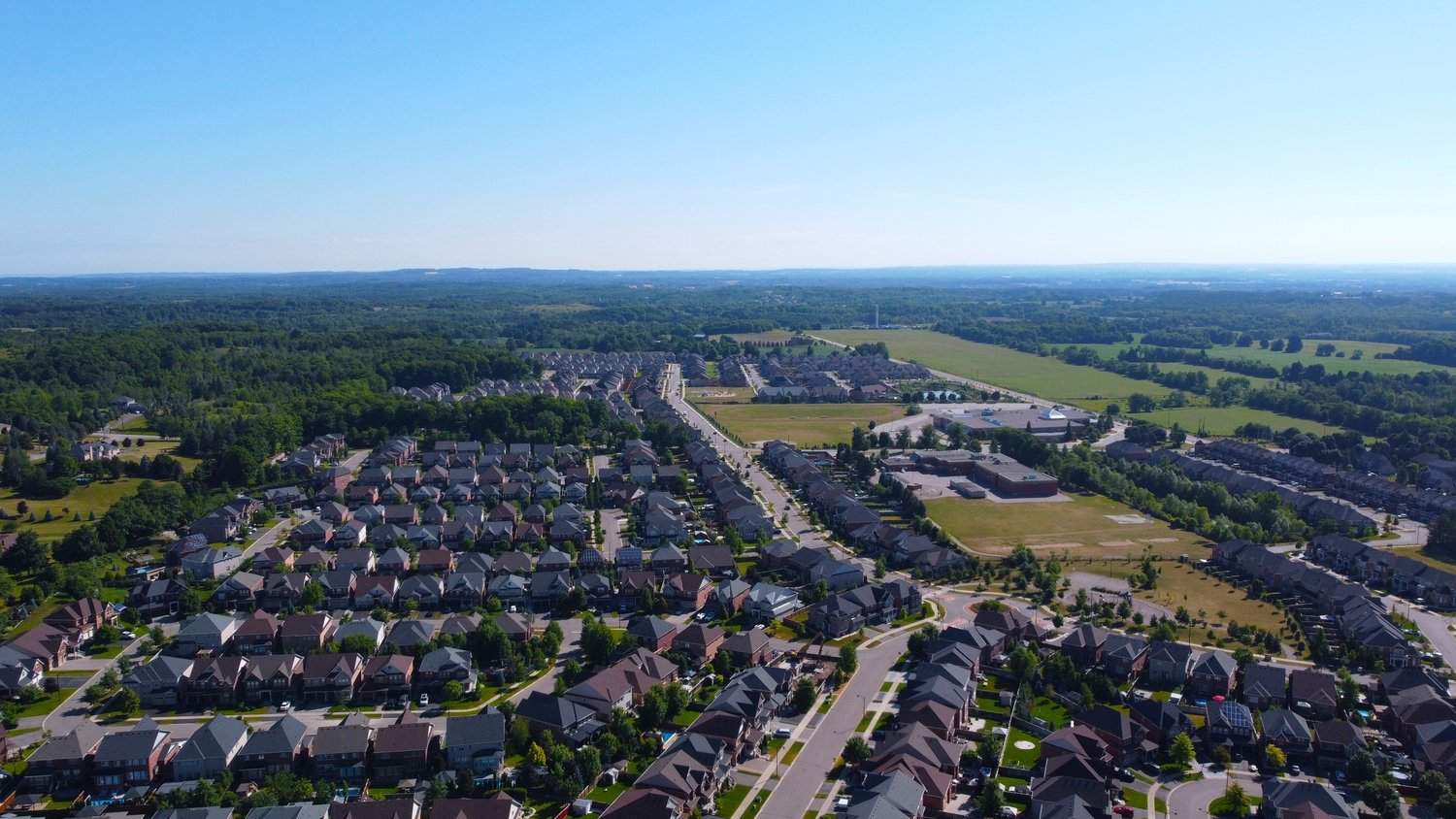 A rural suburb in Caledon East, surrounded by trees and fields under a clear sky.