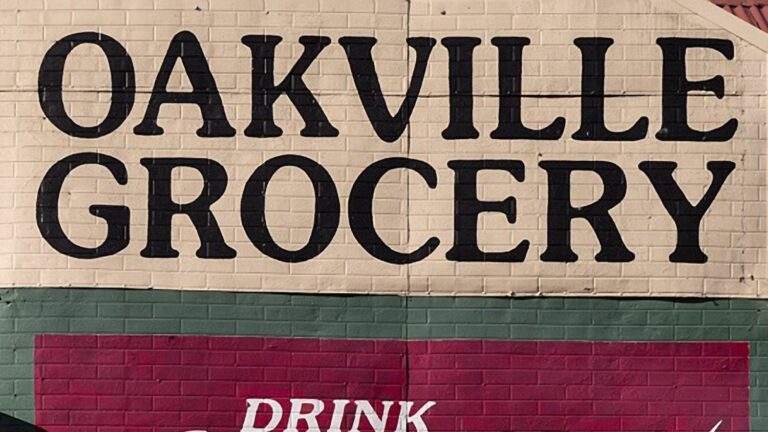 Painted brick building signage for Oakville Grocery representing the local commercial asphalt paving service area in Oakville ON